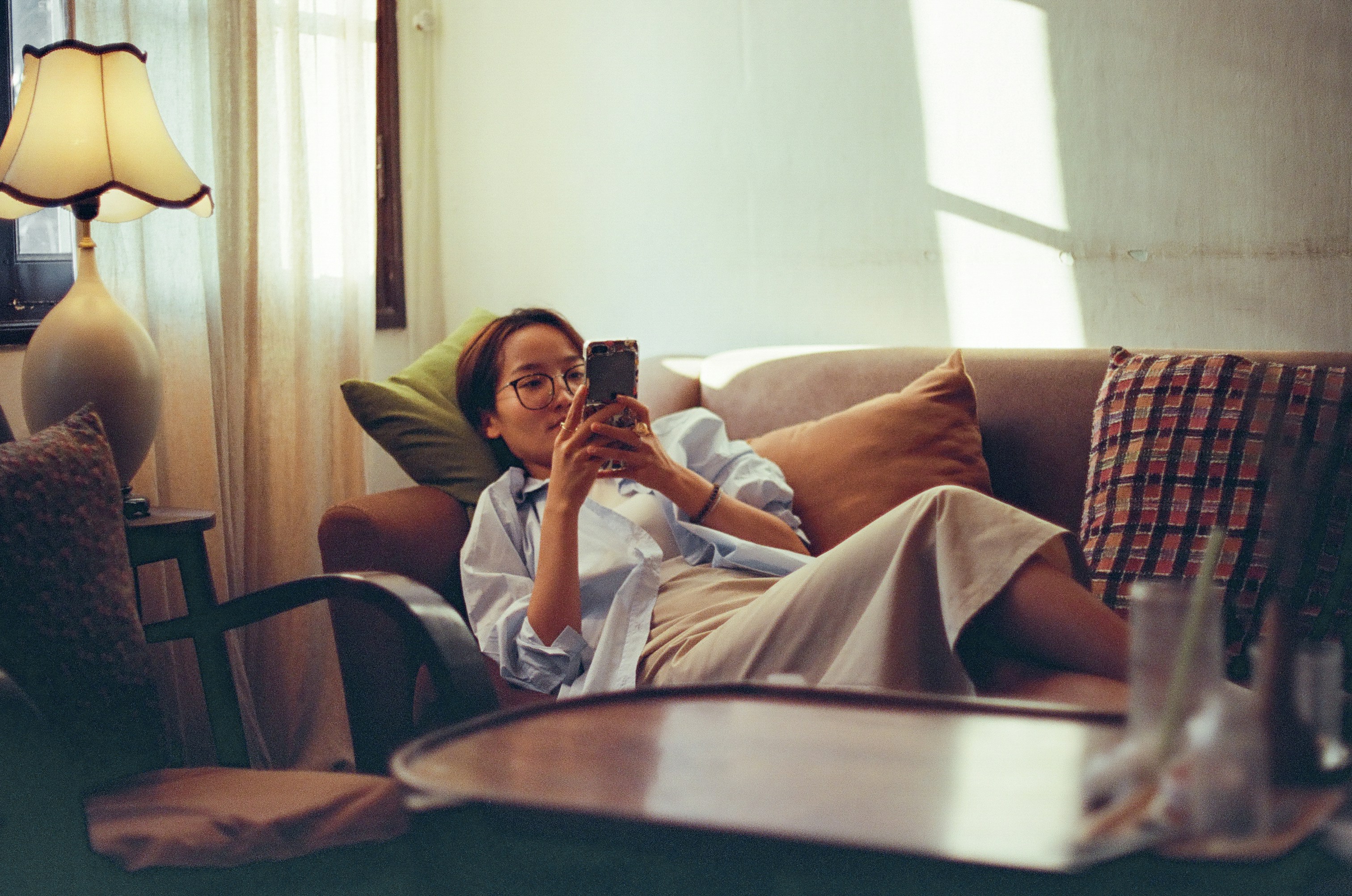 femme sur son téléphone dans son salon